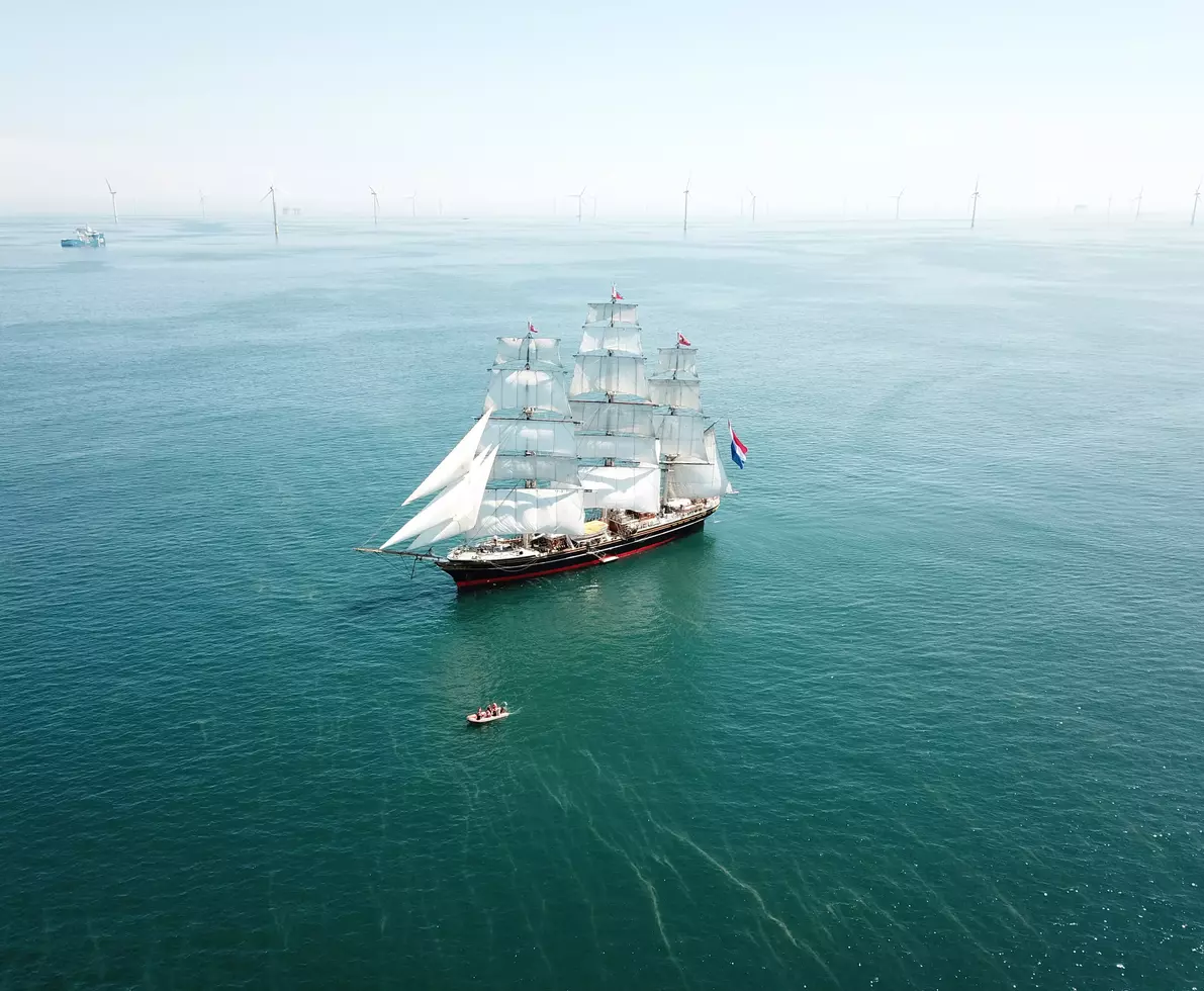Randstad Clipper StadAmsterdam: bird view by of the Clipper in open see with windmill on the background