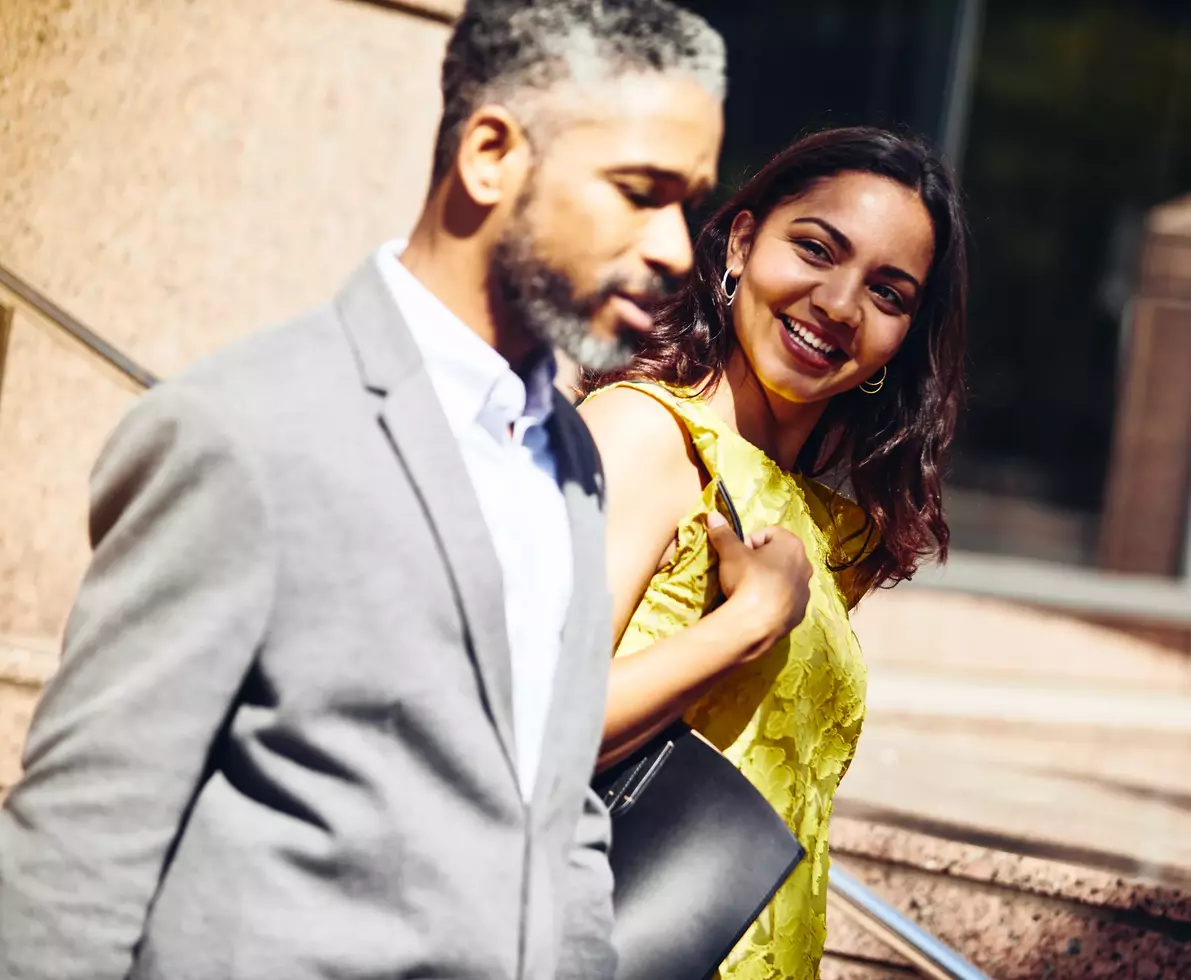 male and smiling female walking outside in the sun