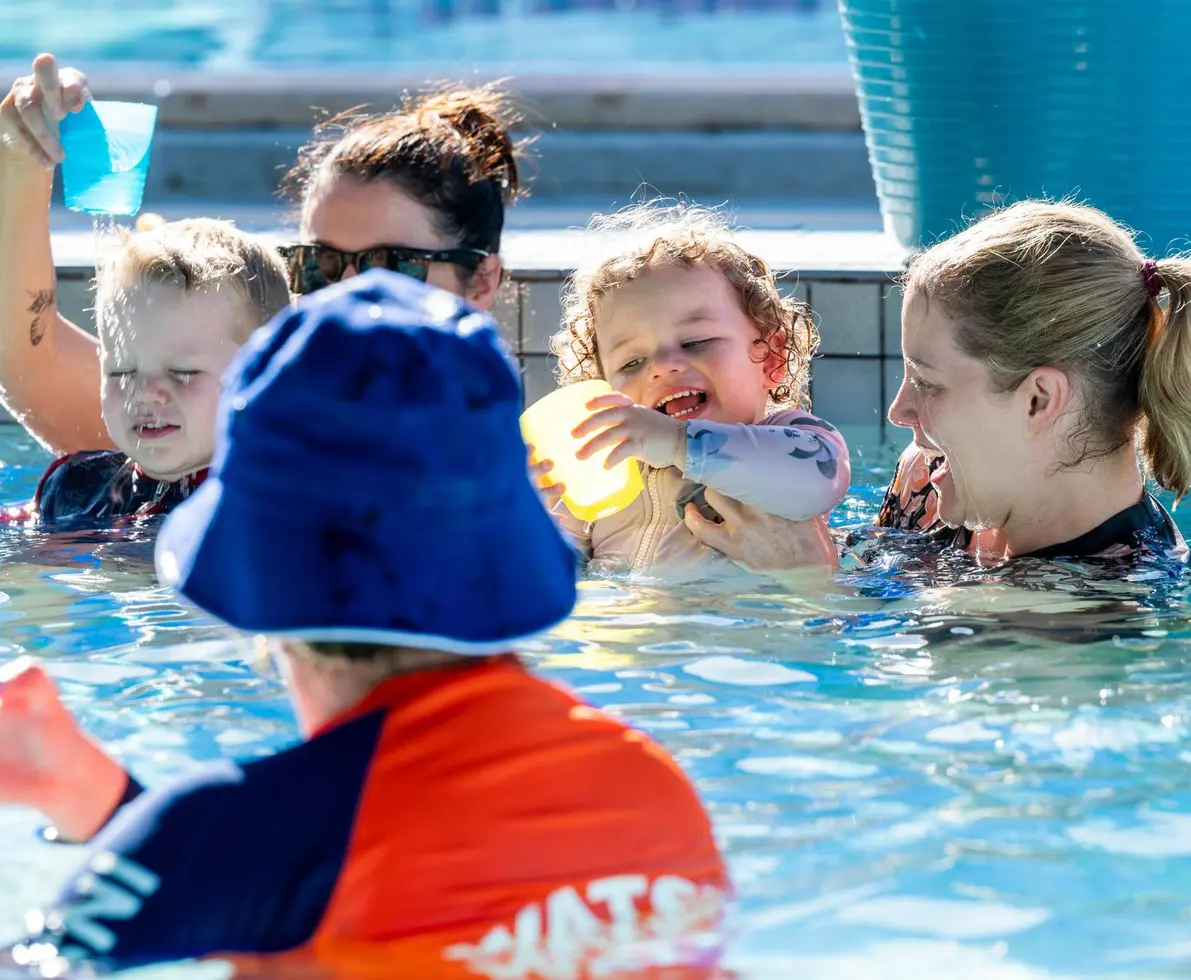 an image of children and carers playing in a swimming pool