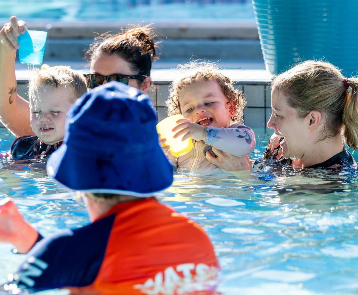 an image of children and carers playing in a swimming pool