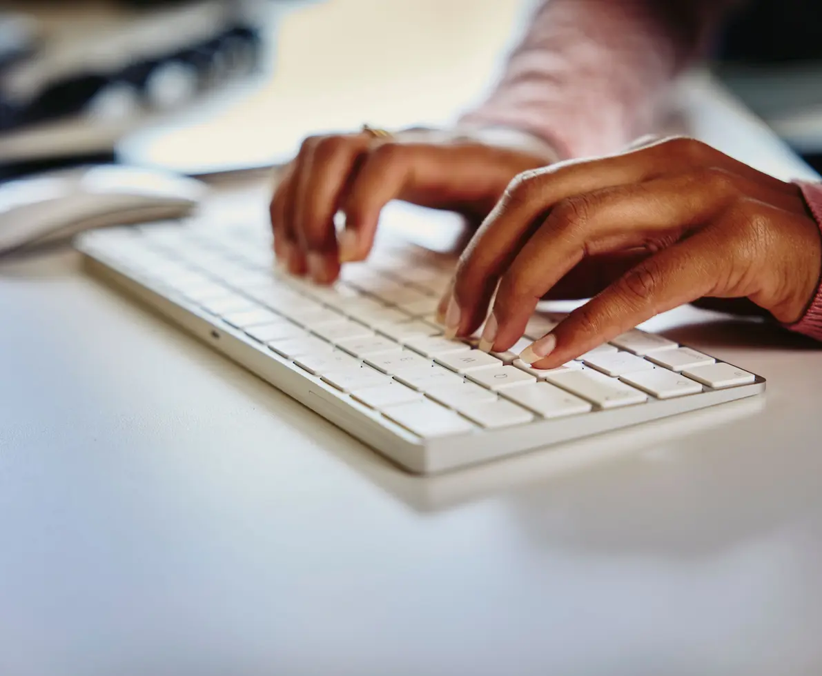 a close up of hands typing on a keyboard