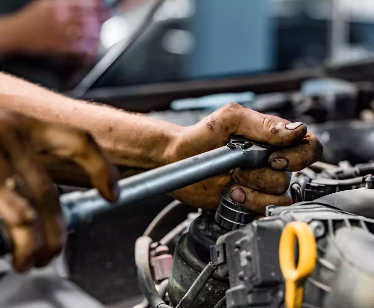 Close up of auto mechanic repairing car engine in car service.