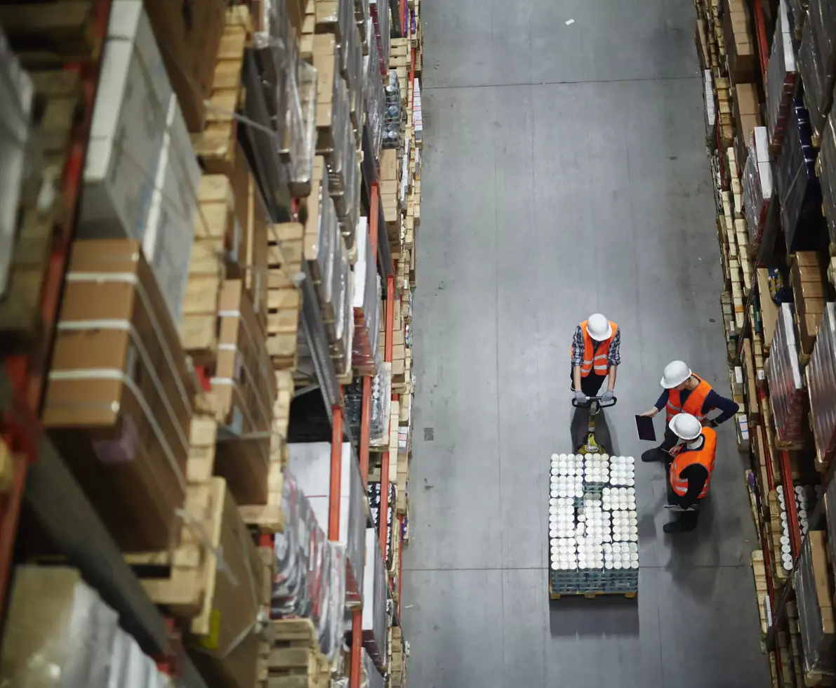 Aerial view of group of workers in uniform and helmets having talk in aisle.