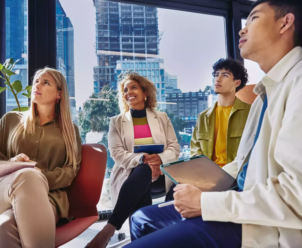 4 persons looking up in the same direction, in a room with glass windows