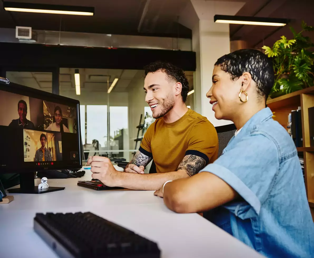 Male and female sitting behind a computer in a video meeting