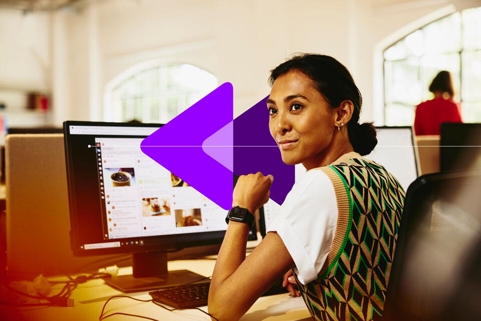 an image of a woman sitting at her desk, looking away from computer screens displaying marketing content