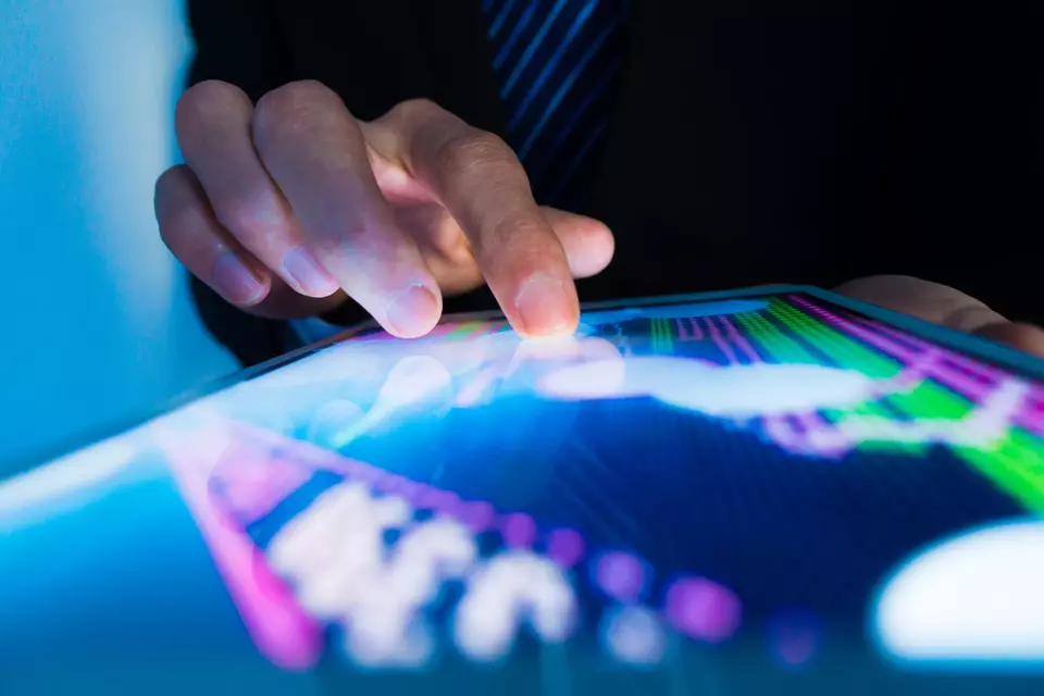 market analyze with digital moniter focus on tip of finger