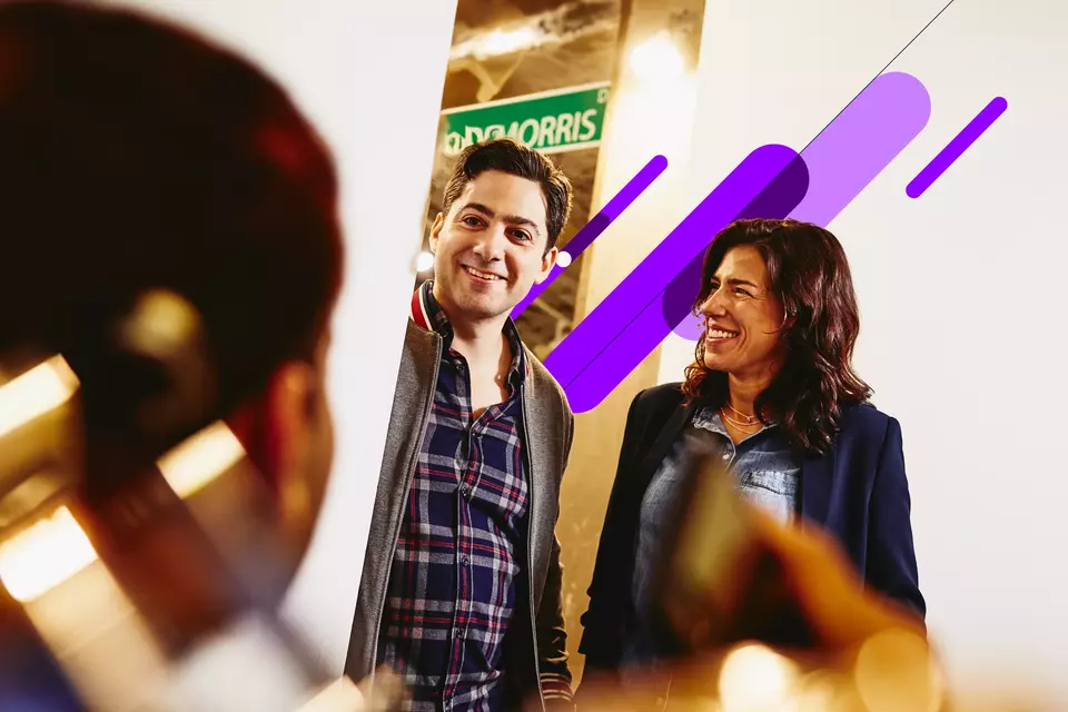 an image of a group of coworkers having a conversation smiling in the office