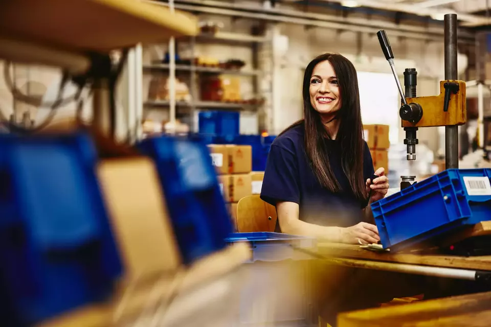 Smiling female working on a maleufacturing site.
