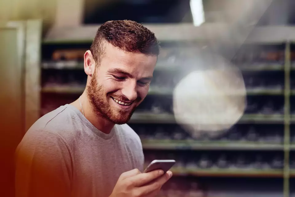 male smiling while looking at this phone.
