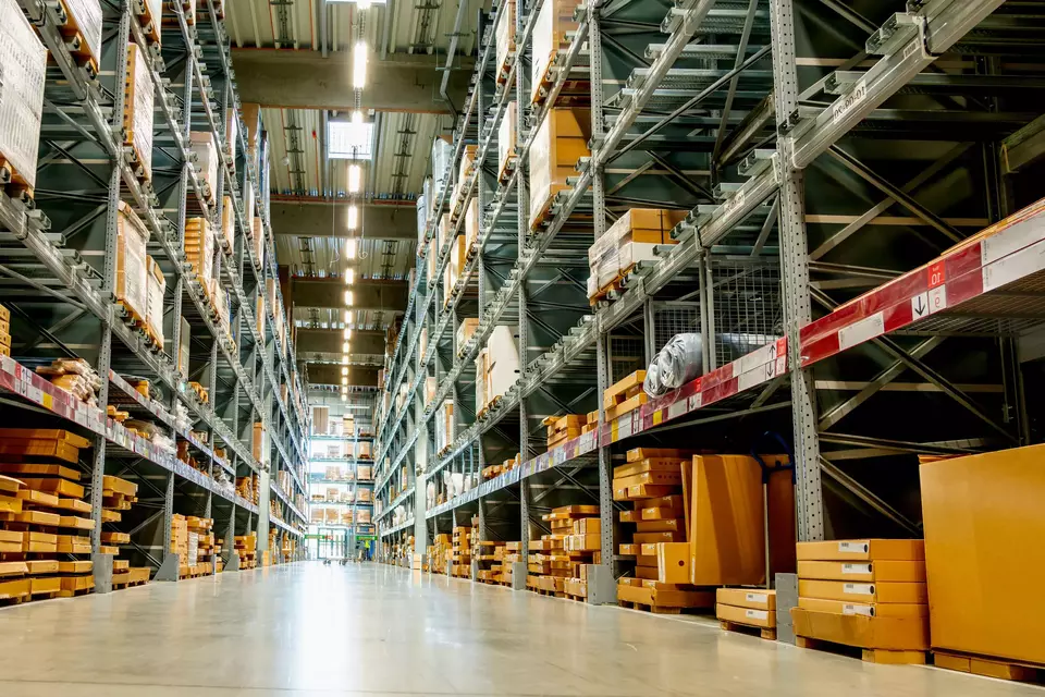 Frog view in a large warehouse in the aisle between the shelves and racks.