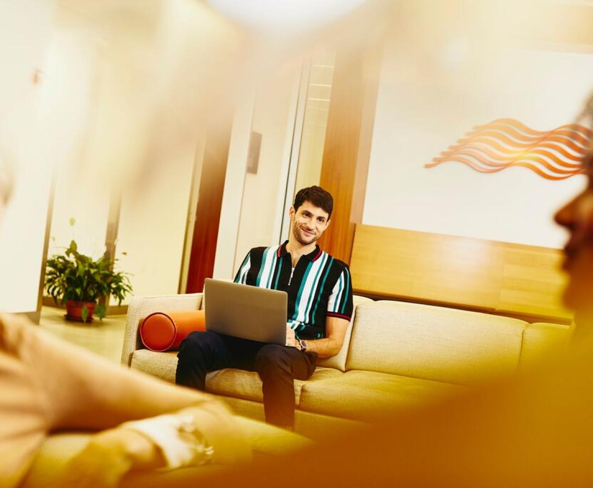 A photo of a smiling man using his laptop to submit their cv A photo of a smiling man using his laptop to submit their cv